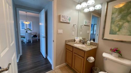 a bathroom with a sink and a toilet and a mirror at Spectacular Sunsets 5 star Resort Condo Across from Beach Sleep 6 Private Shuttle in Destin