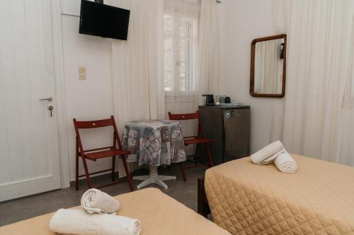 a room with two beds and a table and chairs at Oasis in Kamarai
