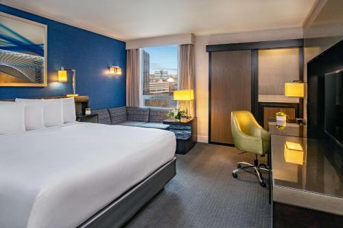 a hotel room with a bed and a desk with a chair at The Royal Sonesta Boston in Cambridge