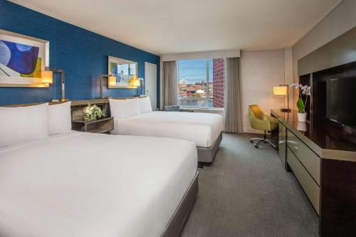 a hotel room with two beds and a television at The Royal Sonesta Boston in Cambridge