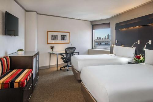 a hotel room with two beds and a desk at The Royal Sonesta Boston in Cambridge