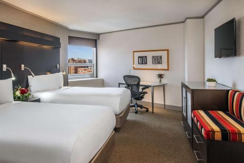 a hotel room with two beds and a desk at The Royal Sonesta Boston in Cambridge