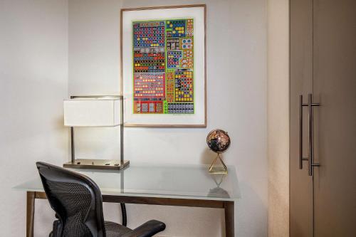 a desk with a chair and a painting on a wall at The Royal Sonesta Boston in Cambridge