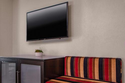 a tv hanging on a wall with a chair at The Royal Sonesta Boston in Cambridge