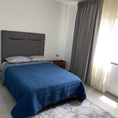 a bedroom with a blue bed with a blue blanket at Playa sur, 5 min playa camina, machado, olas! in Mazatlán