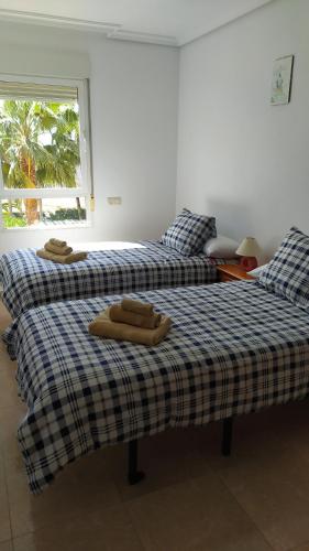 2 camas con toallas encima en una habitación en HABITACIONES EN frente DEL PUERTO en Almería