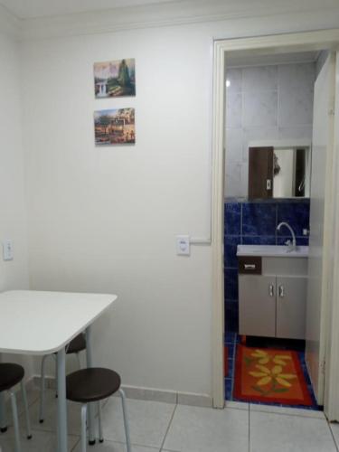 a kitchen with a table and chairs and a sink at Espaço completo bem localizado c estacionamento in Foz do Iguaçu