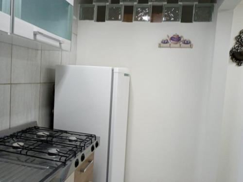 a white refrigerator in a kitchen with a stove at Espaço completo bem localizado c estacionamento in Foz do Iguaçu