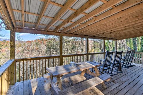 a wooden table and chairs on a deck at Natures Retreat with Hot Tub 7 Mi to Bryson City in Whittier