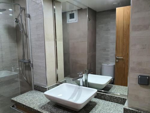 La salle de bains est pourvue d'un lavabo, de toilettes et d'une douche. dans l'établissement Luxe, soleil et confort vue mer pour famille, à Agadir