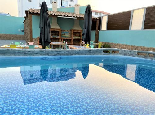 a swimming pool with blue water in front of a house at Marzia Boutique Home in Olhão