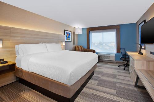 a hotel room with a bed and a desk and a television at Holiday Inn Express & Suites Wooster by IHG in Wooster