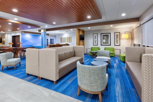a lobby with couches and tables and chairs at Holiday Inn Express & Suites Wooster by IHG in Wooster