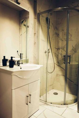 une salle de bain blanche avec une douche et un lavabo dans l'établissement Le Jacquemart, à Dijon