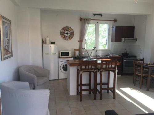 una cucina con tavolo, sedie e frigorifero di Mavro lithari Summer Home ad Anávissos