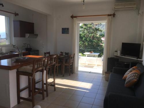 un soggiorno con tavolo e una cucina con vista di Mavro lithari Summer Home ad Anávissos