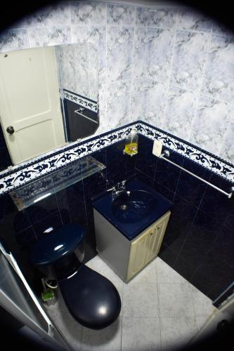 a bathroom with a blue toilet and a sink at Hermoso Apartamento Ubicado en Zona Céntrica de Medellín in Medellín