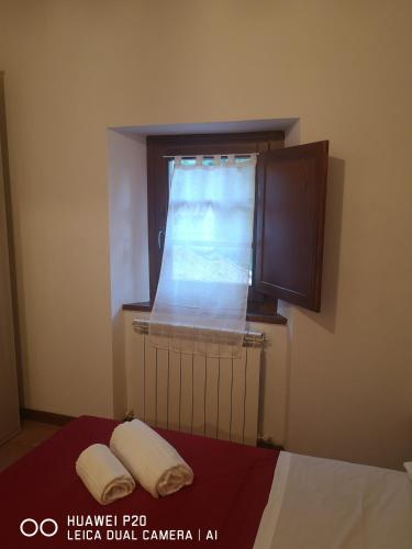 a window in a room with a bed and two towels at Mulini di Verrucole in Naggio