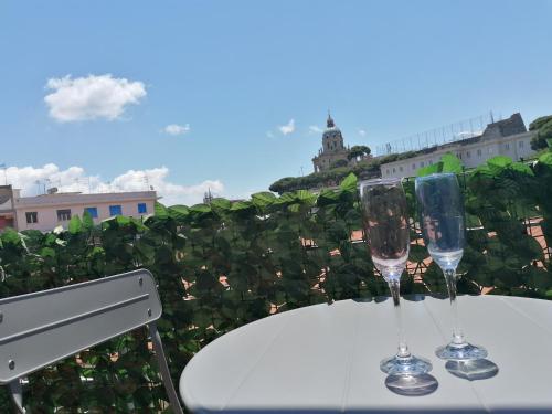 two wine glasses sitting on a table on a balcony at GIOVANNA HOME COLLECTION in Messina