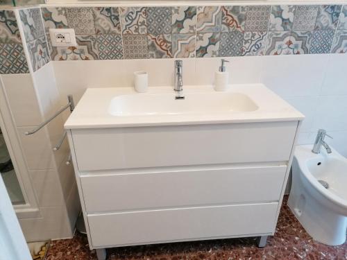 een badkamer met een witte wastafel en een toilet bij GIOVANNA HOME COLLECTION in Messina