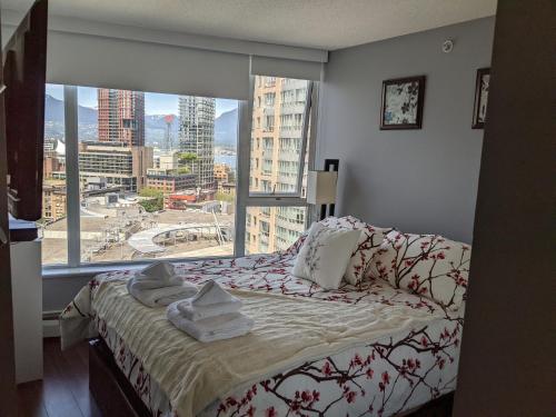 a bedroom with a bed and a large window at Vancouver Downtown Accommodation in Vancouver