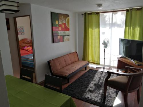 sala de estar con sofá y TV en Departamento Hospedaje Rancagua Centro, en Rancagua