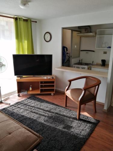 a living room with a television and a chair at Departamento Hospedaje Rancagua Centro in Rancagua