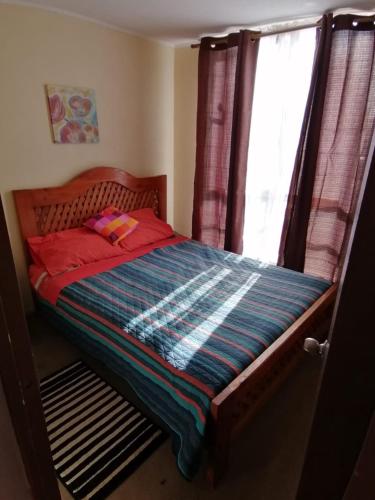 a small bed in a bedroom with a window at Departamento Hospedaje Rancagua Centro in Rancagua