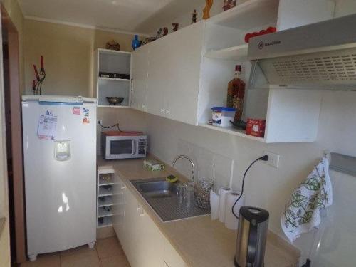 a small kitchen with a refrigerator and a sink at Departamento Hospedaje Rancagua Centro in Rancagua