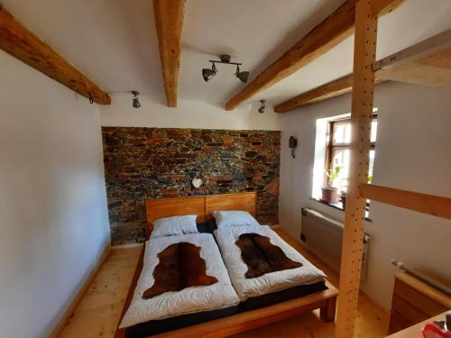 - une chambre avec un lit dans une pièce dotée d'un mur en briques dans l'établissement Statek Žíšov, à Žíšov