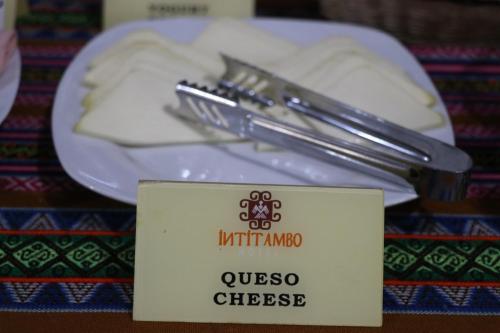 a plate of cheese with a knife and fork on a plate at Intitambo Hotel in Ollantaytambo