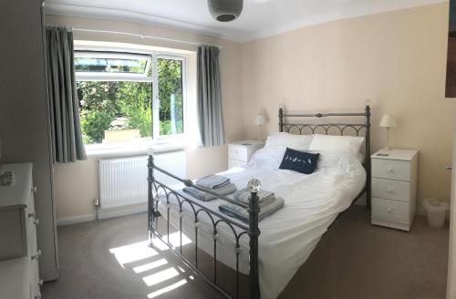 a bedroom with a bed with white sheets and a window at Exe View in Dawlish