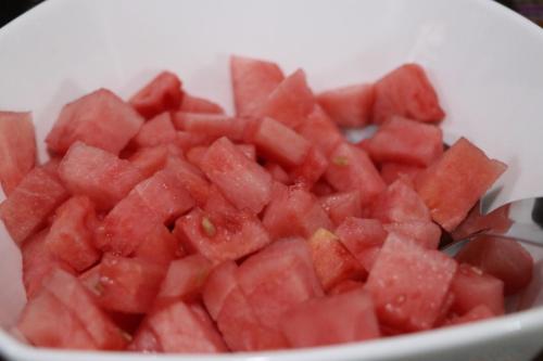 a bowl of diced red watermelon with a spoon at Intitambo Hotel in Ollantaytambo