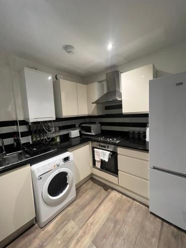 una cucina con lavatrice e frigorifero di Lovely 3 Bedroom, Heart of London, Euston Kings cross st pancras a Londra