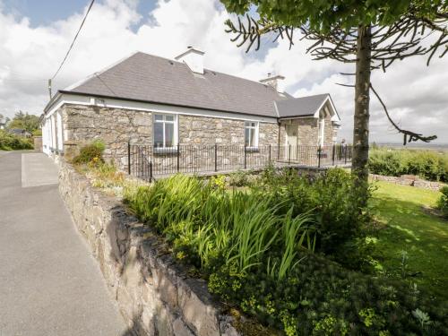 a stone house with a fence in front of it at Prague House in Lettermore