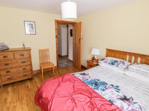 a bedroom with a large bed and a wooden dresser at Prague House in Lettermore