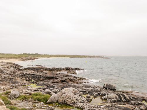 a large body of water with rocks and the ocean at Roundstone Bay View in Roundstone