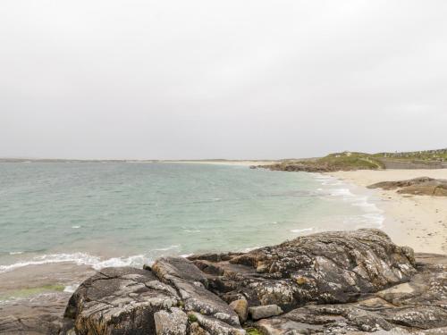 a beach with some rocks and the ocean at Roundstone Bay View in Roundstone