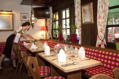 a woman standing at a table in a restaurant at Ringhotel Bömers Mosel Landhotel in Alf