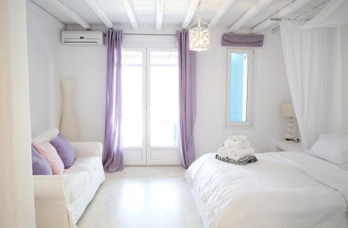 a white room with two beds and a couch at Villa ANASA private Pool & Jacuzzi 8pax at Panormos in Panormos Mykonos