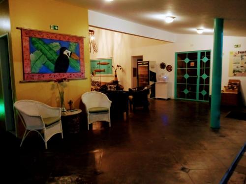 a living room with chairs and a painting on the wall at Pousada Marahú in Porto De Galinhas