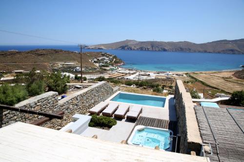 a villa with a swimming pool and a view of the ocean at Villa ANASA private Pool & Jacuzzi 8pax at Panormos in Panormos Mykonos