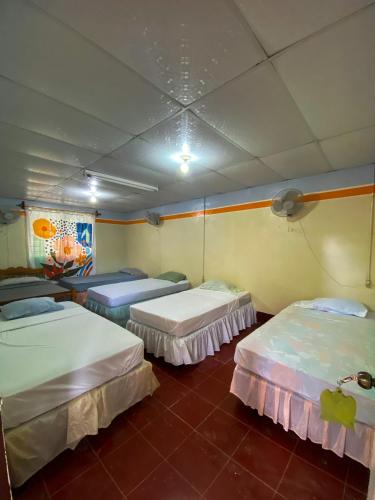 a room with three beds in a room at Hostal tortuga viajera in Moyogalpa