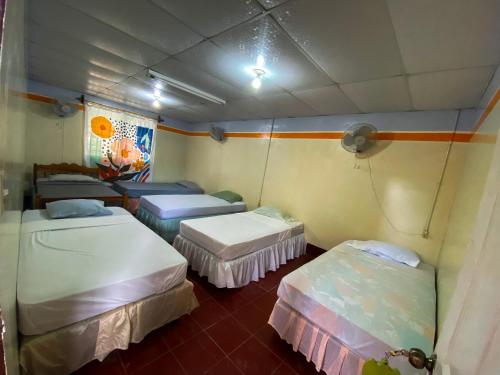 a room with three beds in a room at Hostal tortuga viajera in Moyogalpa