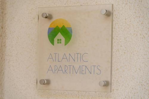 a sign for an atlantic apartments on a wall at Vista Mar in Porto Santo