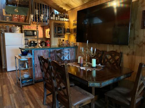 a dining room with a wooden table and a television at HomeAway Cabins and Animal Sanctuary in Boerne