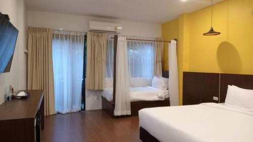 a hotel room with two beds and two windows at Blue Orchid Beach Krabi - SHA Certified in Ao Nam Mao