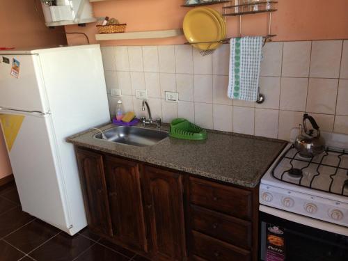 a kitchen with a sink and a white refrigerator at Ciudad de las Colinas in Victoria
