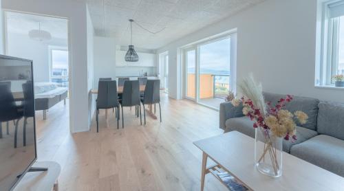 a living room with a couch and a table with chairs at New / Stunning Sea View / Light / 3 BR in Tórshavn