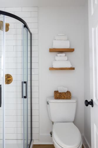 a bathroom with a shower and a toilet and towels at Inn on the Beach in Harwich Port